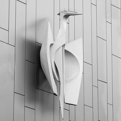 The image features a wall with a unique sculpture attached to it. This artistic piece is made of metal and has an interesting design, resembling a bird or a duck. It appears to be mounted on the side of the building, drawing attention as a decorative element.