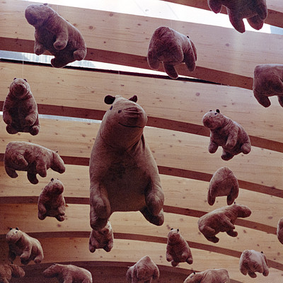 The image features a large number of teddy bears hanging from the ceiling. There are at least 14 teddy bears in various positions, some closer to the camera and others further away. They appear to be arranged in an artistic manner or possibly as part of a decoration.