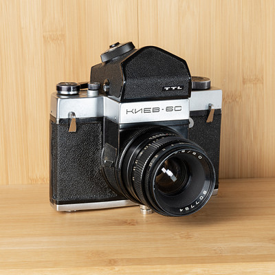 The image features a vintage black and white camera sitting on top of a wooden table. The camera is an old-fashioned model, possibly a Kodak, with its lens open. It appears to be the main focus of the scene, drawing attention due to its classic design and nostalgic appeal.