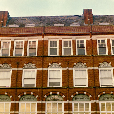 The image features a row of brick buildings with many windows. These buildings are situated next to each other, creating an impressive architectural display. There is a total of 14 windows visible on the front of these buildings, showcasing various styles and designs.