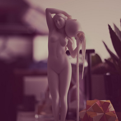 The image features a statue of a naked woman holding a sphere, which appears to be a sports ball. She is standing on a base and seems to be posing for the camera. The statue is placed in front of a desk with various items scattered around it.