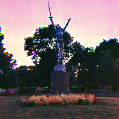 The image is a black and white photo of a statue in the middle of a park. The statue features a person holding a sword, standing on top of a stone pedestal. The statue appears to be an important focal point within the park.